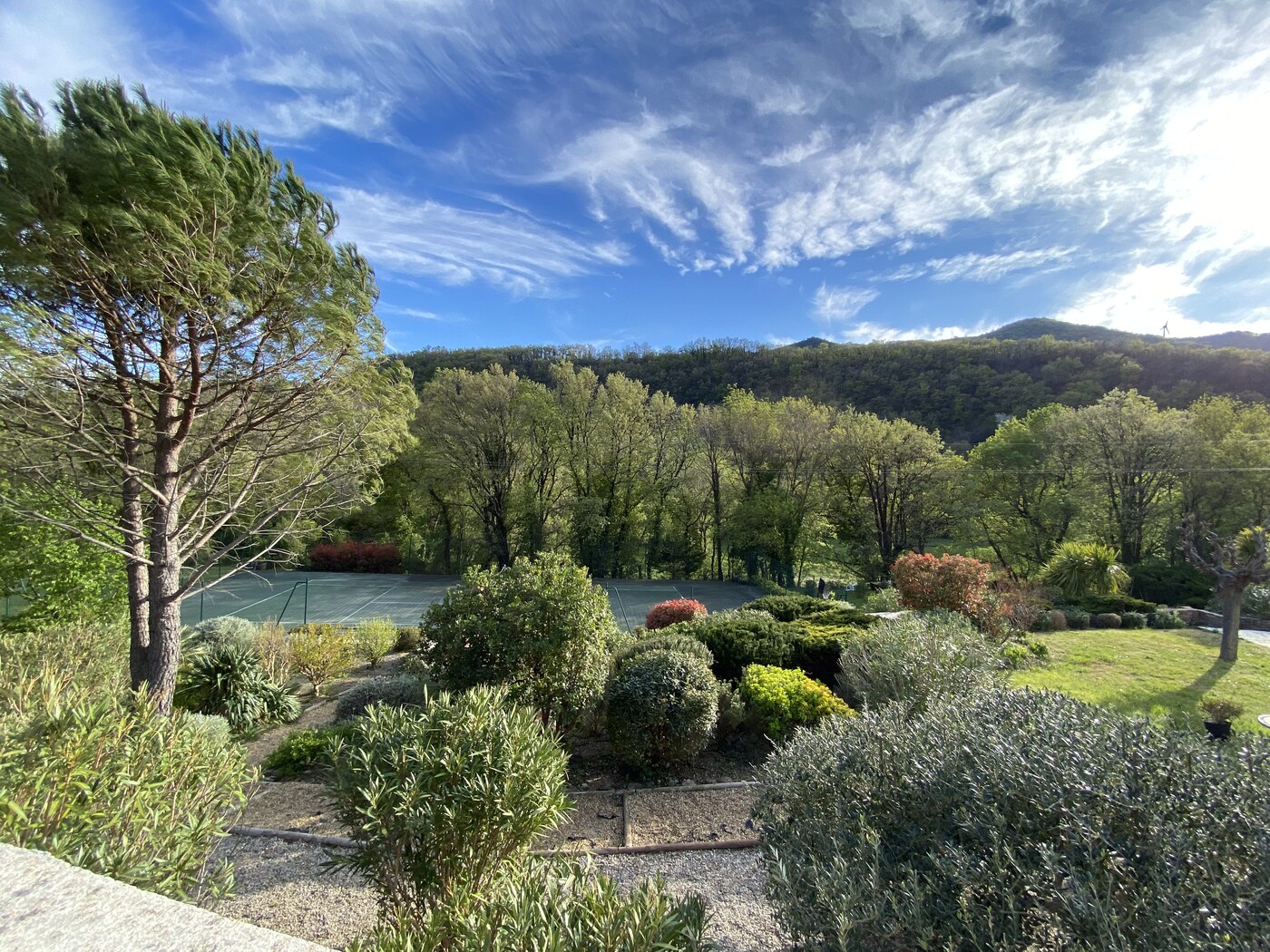 Vue panoramique sur le jardin, le tennis et les collines